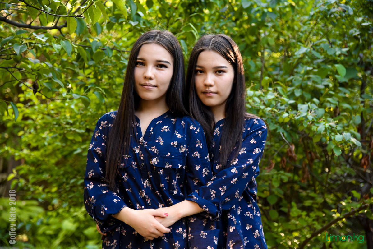 Красивые близняшки девушки сидят на диване в комнате