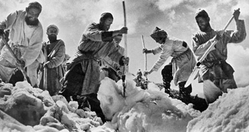 Рабочие раскапывают снег лопатами на строительстве Памирского т
