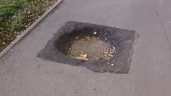 На тротуаре по Айтматова образовалась яма возле люка. Фото