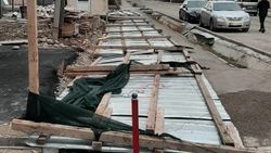 На ул.Бакаева из-за сильного ветра забор строящегося дома упал на тротуар. Фото