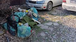 Житель Рабочего городка складирует мусор на улице. Фото