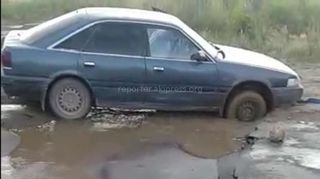 Легковушка застряла на просевшем участке дороги, ведущей в село Кум-Арык (видео)