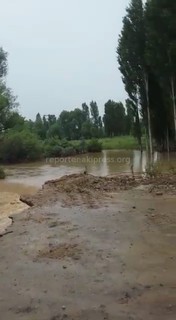 Видео — Воды, вышедшие из реки, <b>размыли участок автодороги</b> в селе Кызыл-Сай Бакай-Атинского района <i>(дополнено)</i>