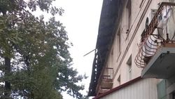 На Турусбекова с крыши дома свисает балка. Фото