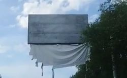 На ул. Алма-Атинской ниже объездной дороги стоит рекламный щит с порванным баннером (видео)