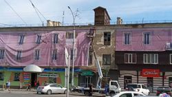 Киевской и Керимбекова дом с облезлой штукатуркой завесили плакатом <i>(фото)</i>