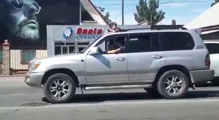 Видео — В Бишкеке двое маленьких детей ехали, высунувшись из люка машины