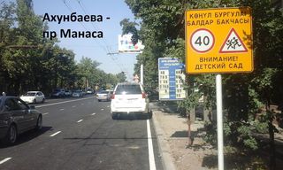 Вдоль улицы Ахунбаева развешаны рекламные знаки и штендеры