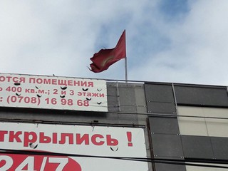 На здании на перекрестке Ахунбаева-Байтик баатыра в Бишкеке более месяца висит порванный флаг, - читатель (фото)
