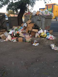 На улице Дэн Сяопина из контейнеров не забирают мусор