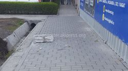 Со строящегося дома в Бишкеке на тротуар упал кусок бетона, чуть не задев девушку (фото)