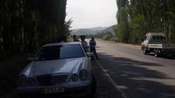 На автодороге Ош-Иркештам сотрудник ООБДД и мужчина в гражданской одежде останавливают автомобили (фото)