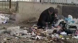 Мужчина собирает использованные одноразовые маски с мусорки. Видео
