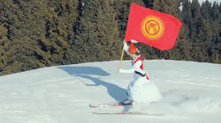 Кыргызстанка скатилась на лыжах с флагом Кыргызстана и в национальном платье. Видео