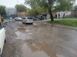 Лужа на Куренкеева-Логвиненко в Бишкеке мешает дорожному движению и затапливает дворы домов (фото)