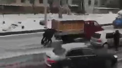 Парни толкают грузовик, который не может выехать из-под моста из-за гололеда. Видео