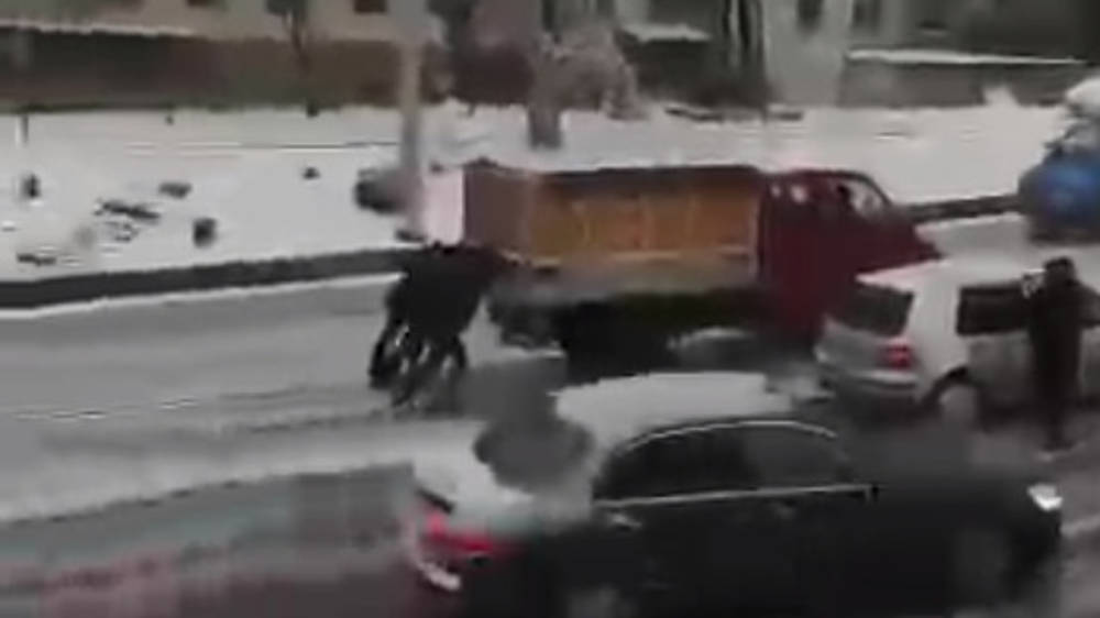 Парни толкают грузовик, который не может выехать из-под моста из-за гололеда. Видео