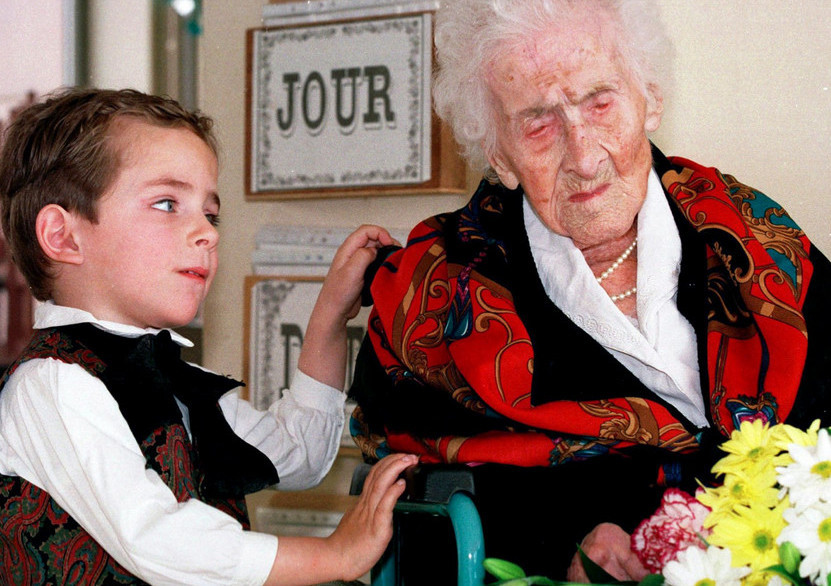Пятилетний мальчик по имени Томас дарит цветы 122-летней Жанне Кальман. Ей в 1997 году принадлежит рекорд продолжительности жизни