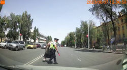 Инспектор помогает бабушке перейти через дорогу в неположенном месте
