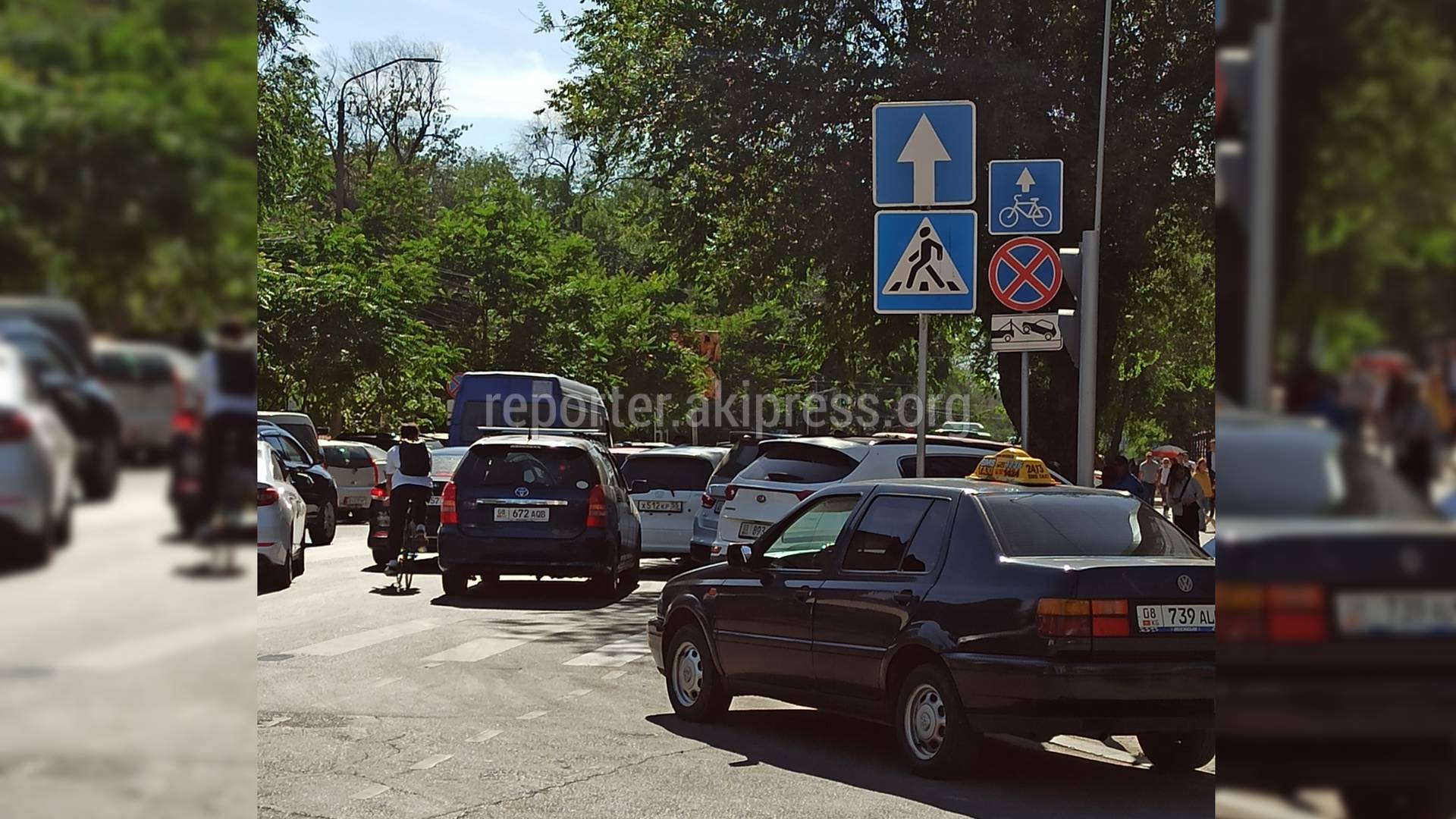 Водители паркуют третьим рядом машины на велодорожке под запрещающим знаком  на перекрестке Токтогула-Акиева