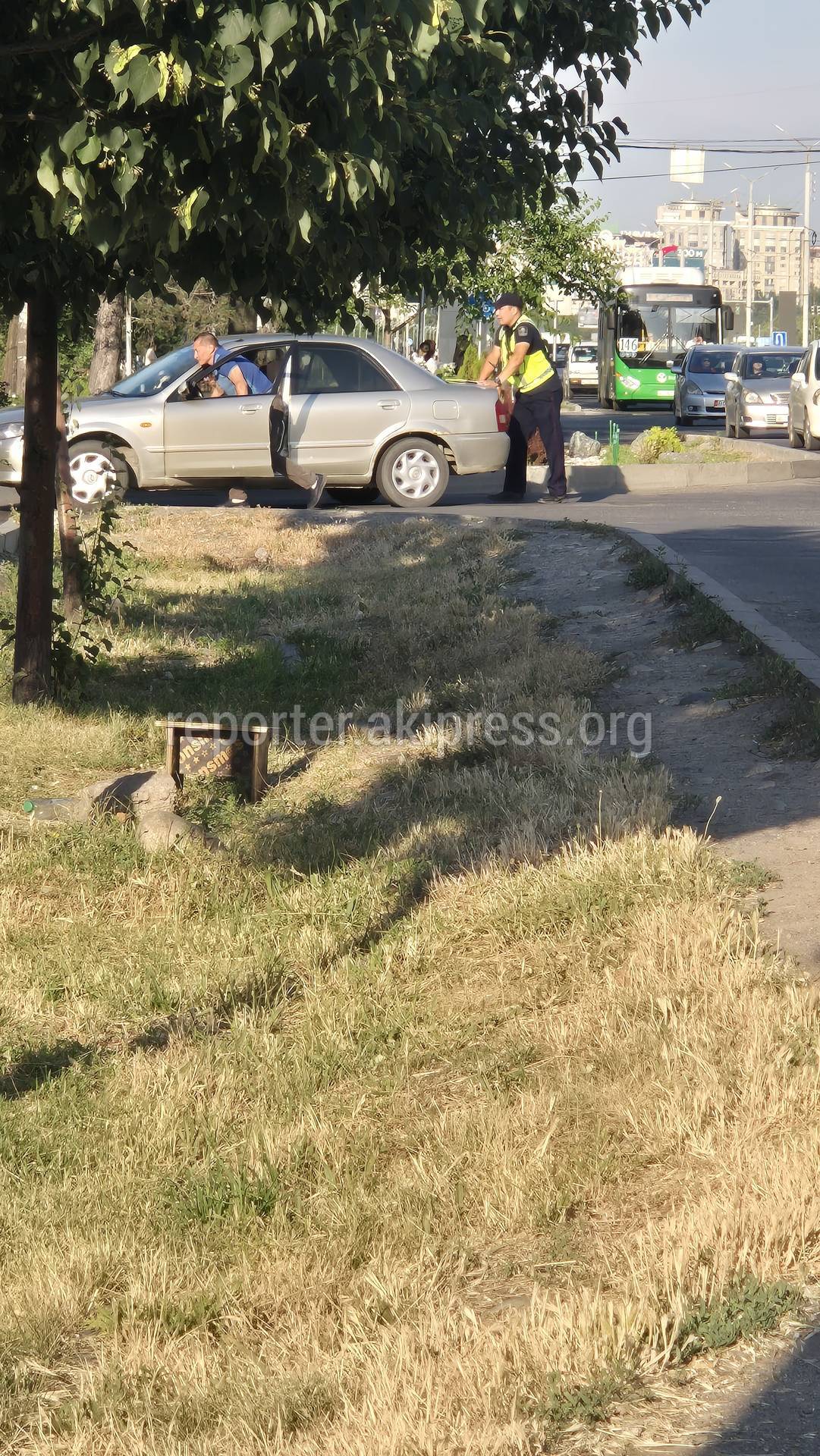 Патрульный помогает водителю толкать заглохший автомобиль. Фото