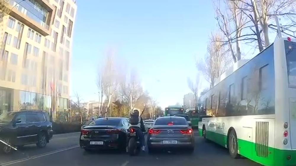 Мотоциклист в пробке заехал между двумя машинами, врезался в одну из них и уехал. Видео