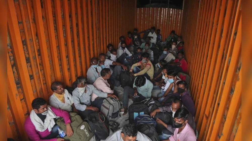 Мигранты из штата Уттар-Прадеш сидят внутри контейнера в надежде вернуться в свои деревни во время тотального карантина, Хайдарабад, Индия