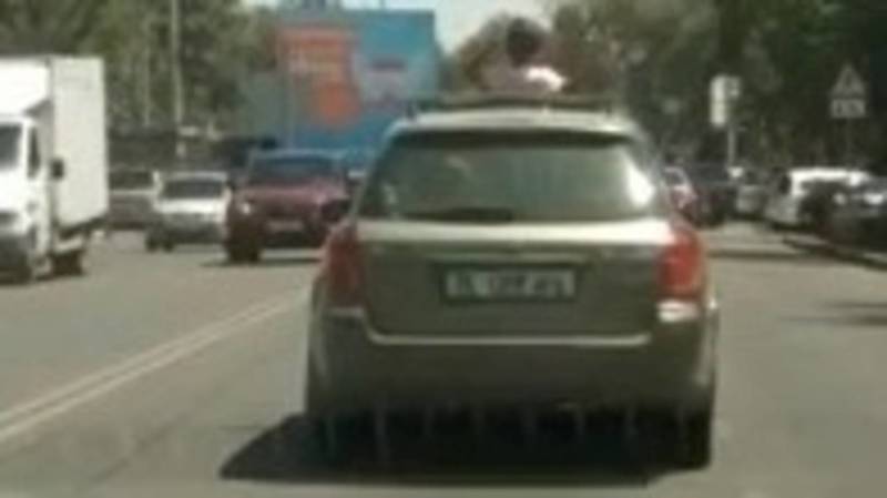 В Бишкеке ребенок едет, высунувшись из люка машины. Видео