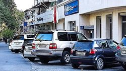 Возле банка KICB машины припаркованы на тротуаре. Фото