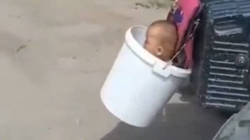 Мужчина посадил малолетнего ребенка в ведро, которое прицепил к трактору. Видео