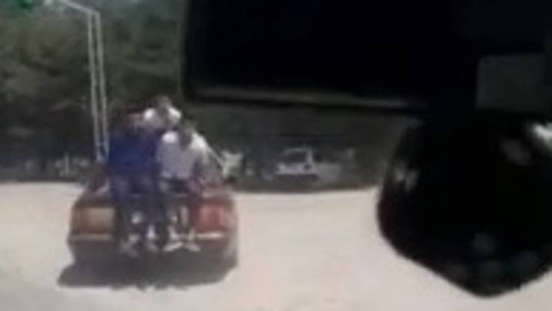 В селе Селекционное двое парней ехали, сидя на багажнике машины. Видео