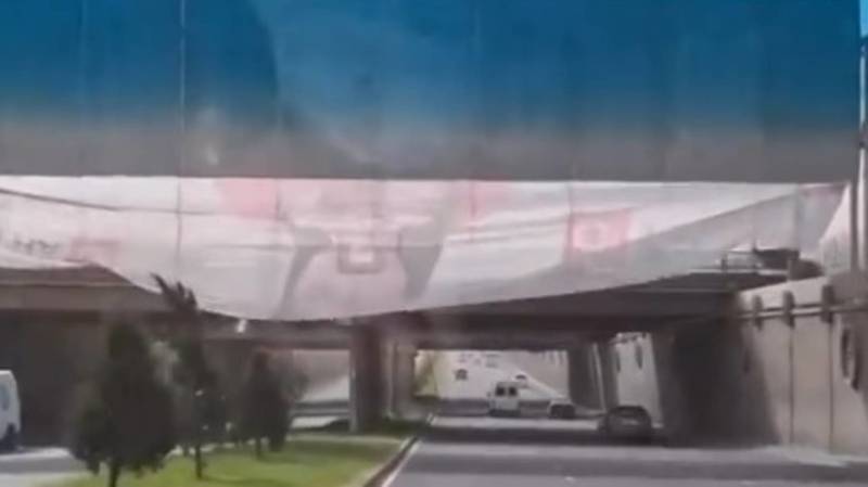 Огромный рекламный баннер опасно свисает над дорогой. Видео