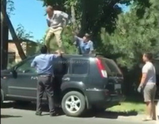 В Бишкеке мужчина, не подчинившись милиционерам, забрался на крышу машины <i>(видео)</i>