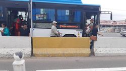Автобус №7 производит посадку и высадку пассажиров на проезжей части. Фото