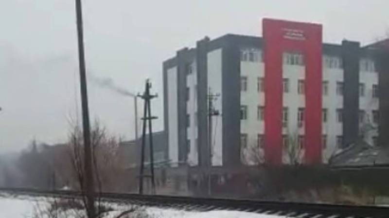 Из трубы здания университета идет черный дым. Видео