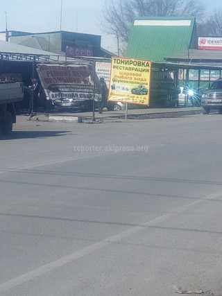 «Бишкекасфальтсервис» демонтирует баннер, установленный на дорожный знак около рынка «Кудайберген»