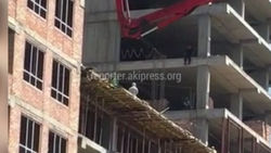 Мужчина сел, свесив ноги, на строящемся многоэтажном доме <i>(видео)</i>