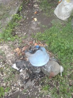 Жительница села Пригородное сжигает пластиковый мусор возле дома