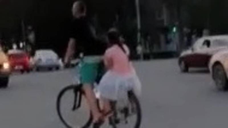 Велосипедист с девочкой на багажнике остановился на оживленном перекрестке на проспекте Чуй. Видео