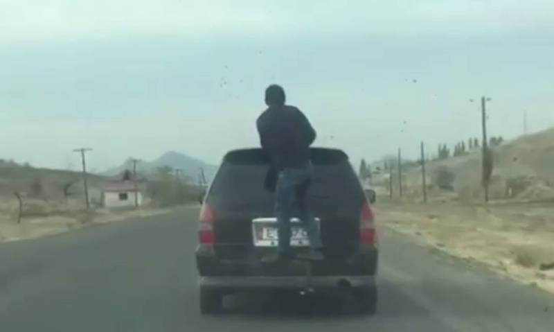 Видео – В Оше парень ехал зацепившись за багажник машины