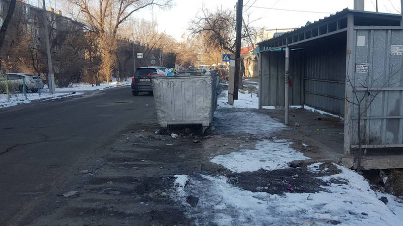 На ул.Койбагарова мусорные контейнеры стоят на проезжей части дороги. Фото