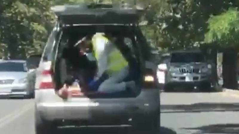 Волонтер качает кислородную подушку, пока больного везут в багажнике машины в больницу. Видео