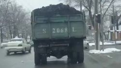 С грузовика, забитого углем, летит пыль. Видео