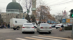 Две машины припаркованы на проезжей части возле мечети. Фото