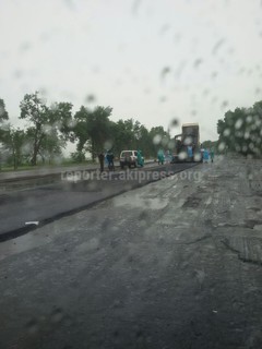 На улице дождь, а строители укладывают асфальт на автодороге, ведущей к аэропорту <i>(фото)</i>