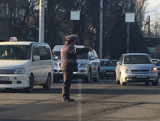 На Боконбаева-Манаса сотрудник регулирует движение автотранспорта рацией