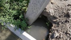 На ул.Менделеева арычная вода размывает основание опоры ЛЭП (фото)
