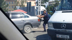 В Караколе милиционер толкает заглохший автомобиль. Видео