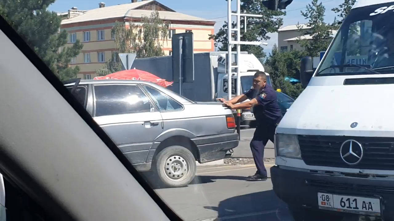 В Караколе милиционер толкает заглохший автомобиль. Видео