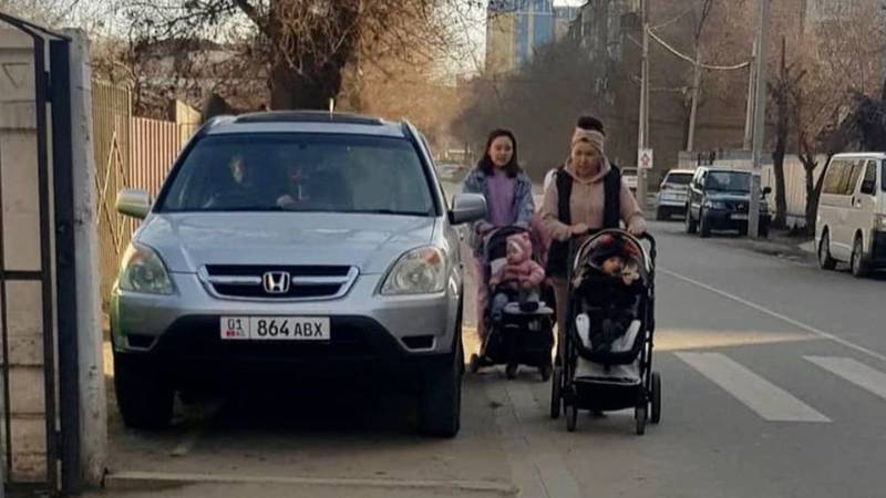 Из-за «Хонды», припаркованной на тротуаре, мамы с колясками выходят на проезжую часть. Фото горожанин